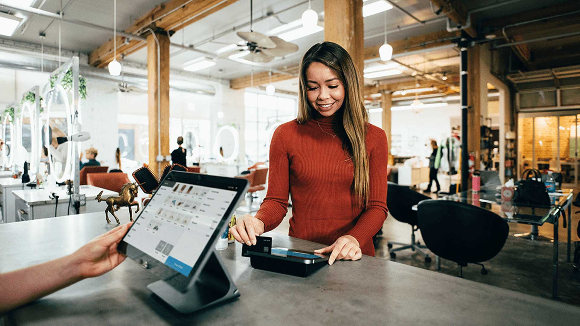A customer swiping their card in a hair salon