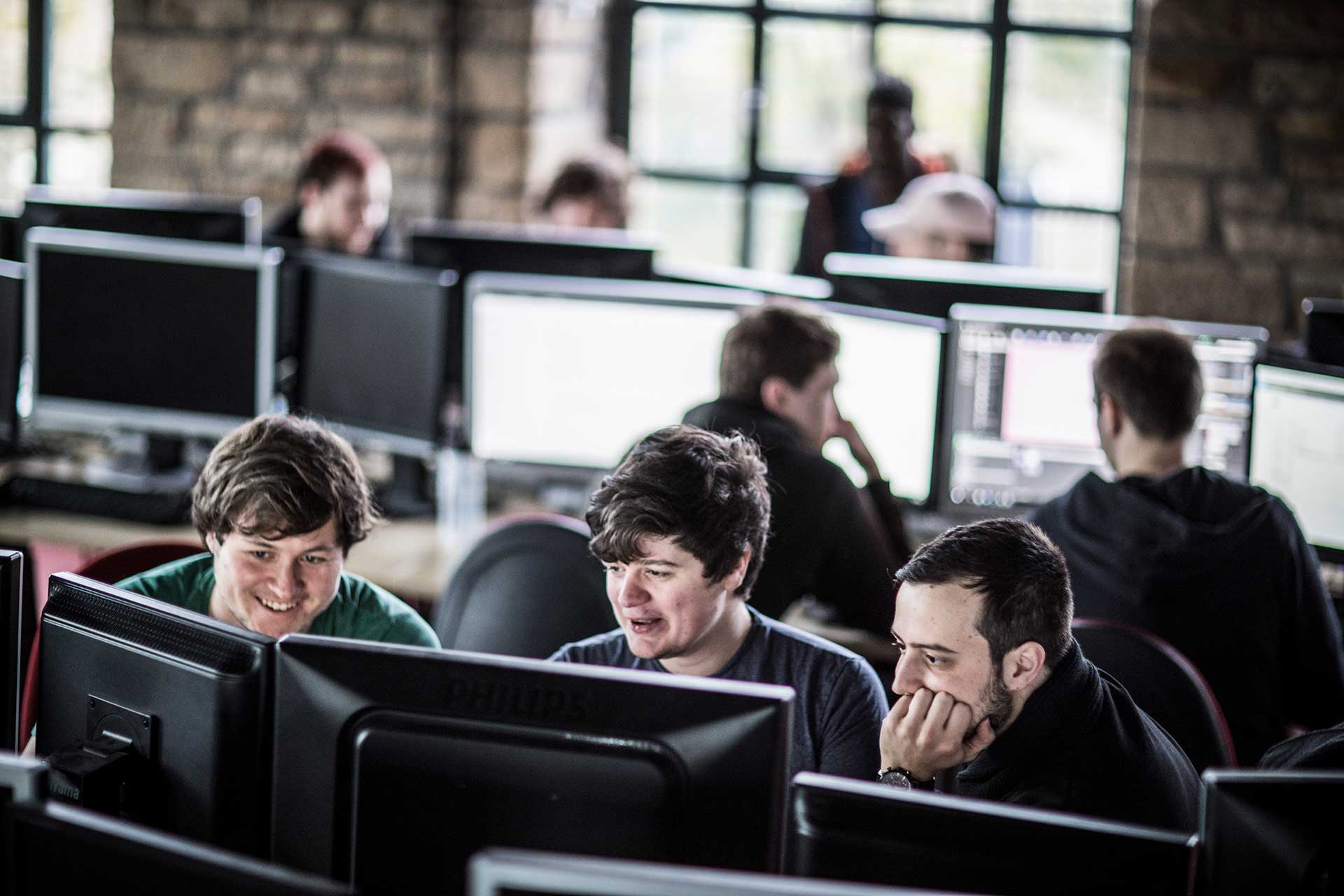 three students sat at computers