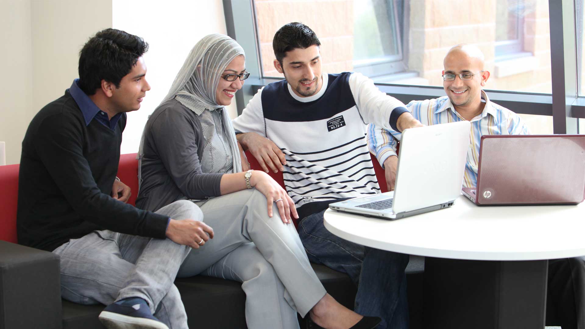 Four students sat around laptops